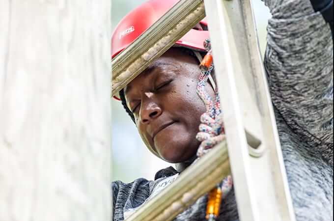 Black woman scaling a ladder. 