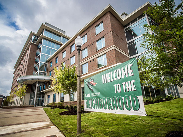 UAB dorm with "welcome to the neighborhood" banner outside. 