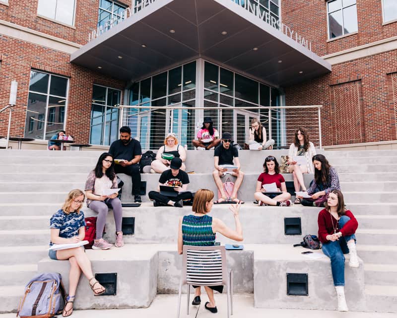 Anthropology students having class on the steps of the building.