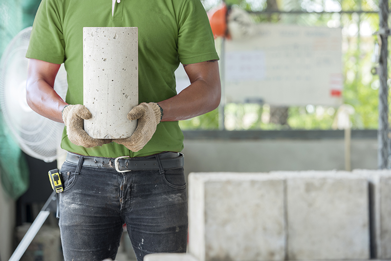 student holding cement cylinder