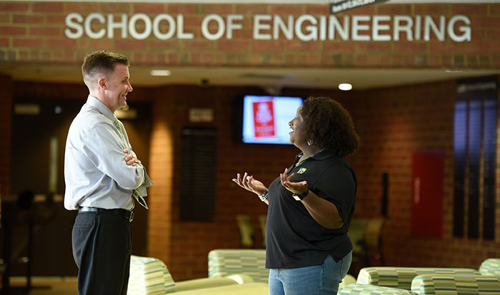 An Information Engineering Management graduate student speaking with a faculty member.