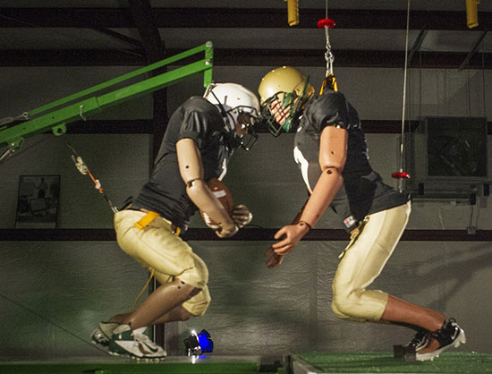Crash-test dummies, one-of-a-kind sleds, and other hardware are used to evaluate football helmets.
