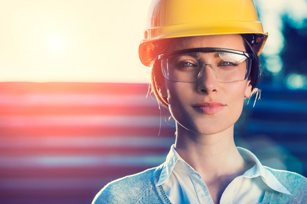 Woman with glasses wearing hardhat.