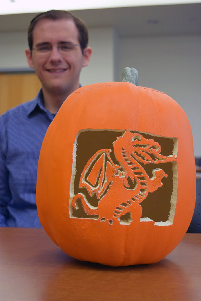 Michael Schultz with pumpkin carved in shape of Blazer the dragon.