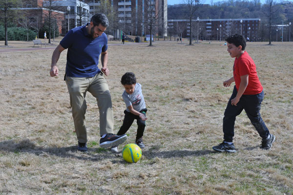 Hisham Abdelmotilib playing soccer with his kids.