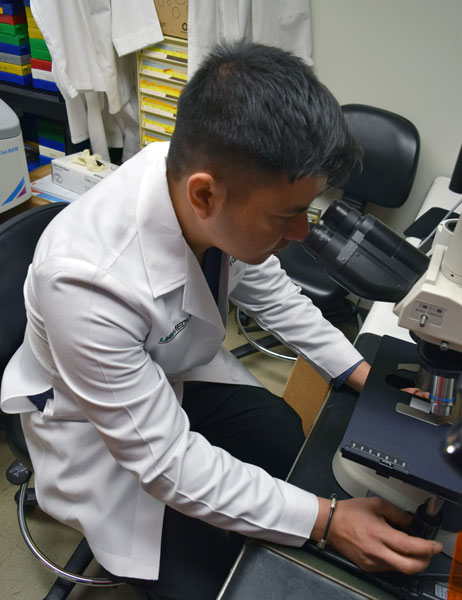 Samir Rana using a microscope.