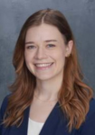 Dr. Wilson Fisher Professional headshot of a woman wearing a navy suit jacket with a white shirt in front of a blue backdrop