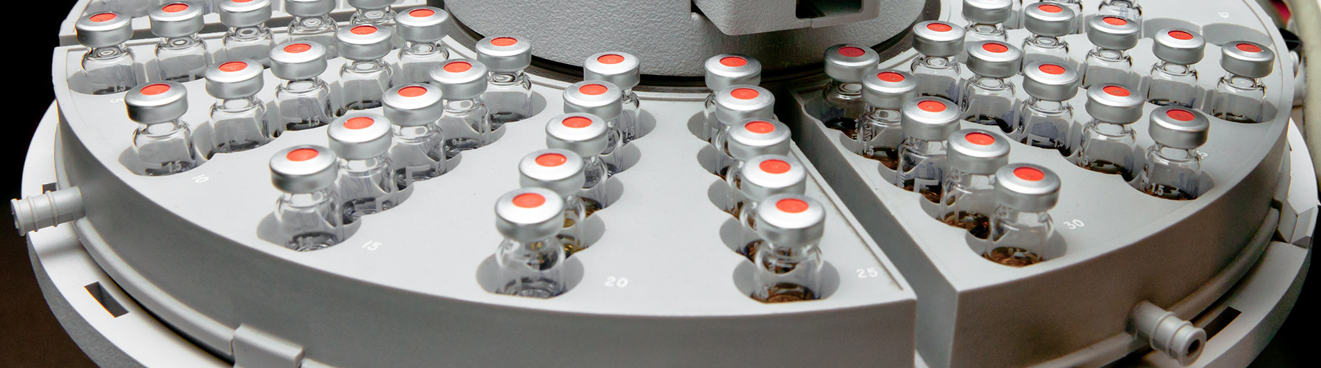 Glass phials sit in a sample carousel after analysis in a laboratory machine.