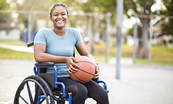 Portrait of a teenage black girl on a wheelchair with a basketball