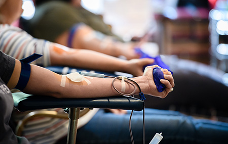 LifeSouth Community Blood Center Blood Drive at Prince of Peace Catholic Church in Hoover on March 30, 2020. From side, a line of outstretched arms of people donating blood.