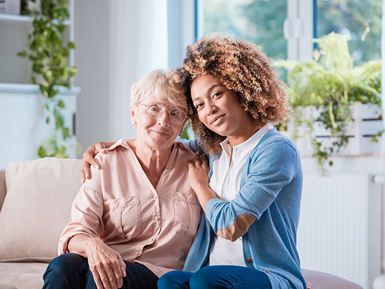 Close-up of home caregiver and senior woman holding hands
