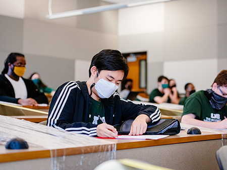 Students wearing face masks are taking notes in a Western Civilization history class in Heritage Hall during the COVID-19 (Coronavirus Disease) pandemic, April 2021.