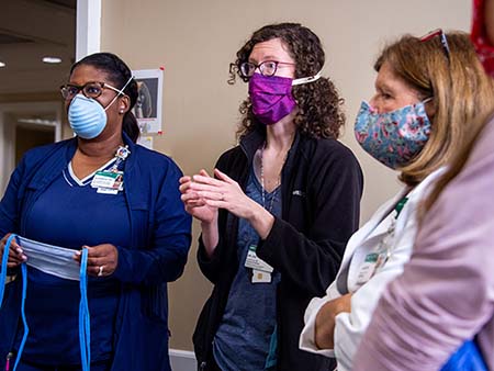 Alvernita McKinney, RN (Infection Prevention Manager, Infection Prevention and Control), Dr. Rachael Lee, MD (Assistant Professor, Infectious Diseases), and another woman, all wearing PPE (Personal Protective Equipment) face masks while at a demonstraton testing the fit of PPE gear at the UAB Hospital COVID-19 (Coronavirus Disease) Command Center in the North Pavilion on April 7, 2020.