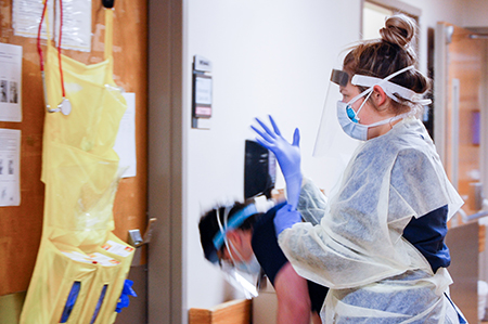 From side, female nurse is wearing Personal Protective Equipment (PPE) while working in the Hospital during the COVID-19 (Novel Coronavirus) pandemic, March 2020.