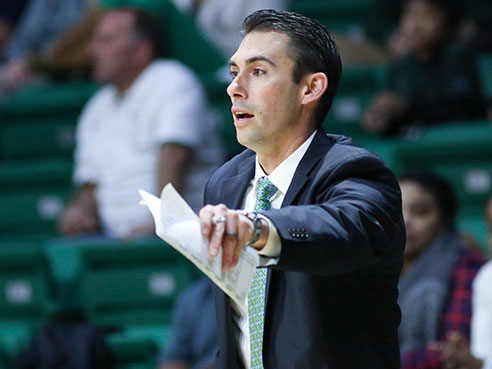 Robert Ehsan coaches on the sidelines of a men's basketball game as associate head coach. (Photo from UAB Sports)