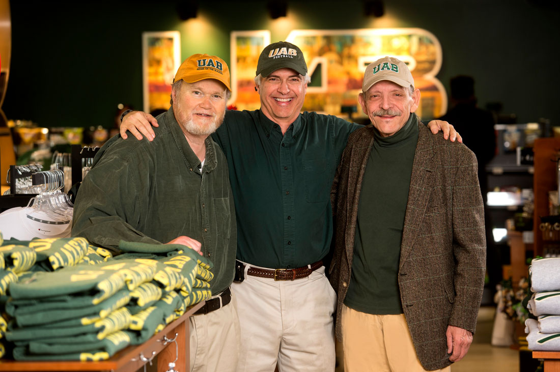 Photo of alumni Tommy Burns, Richard Dewberry, and Chuck Snow wearing UAB clothing at UAB Bookstore