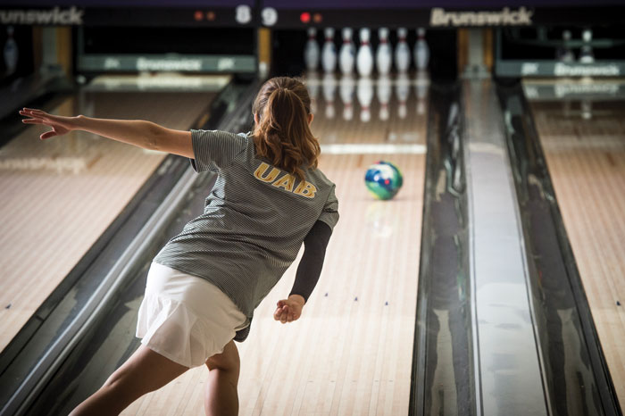 Photo of UAB bowling athlete with ball rolling toward pins
