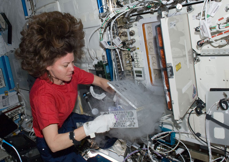 Photo of ISS astronaut opening a UAB freezer