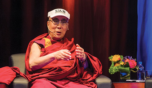 Photo of the Dalai Lama wearing a UAB cap