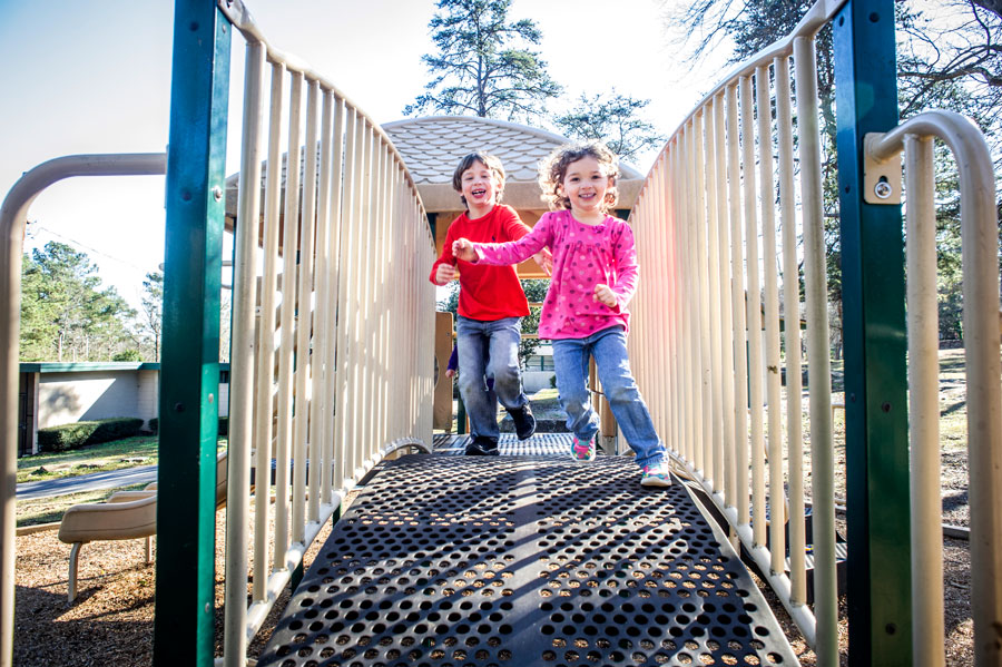 Photo of little boy and little girl on playground bridge