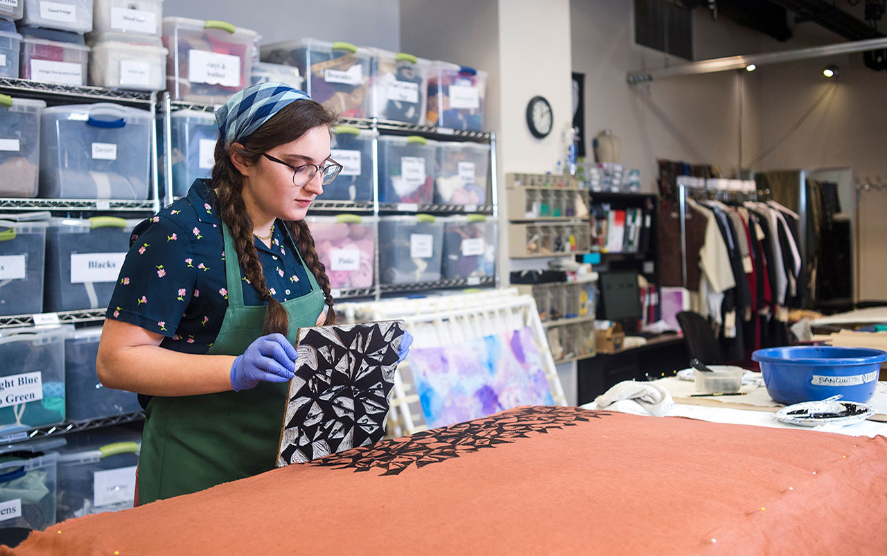 Photo of student block-printing textile in UAB Costume Shop