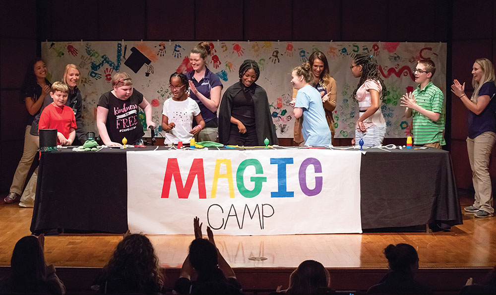 Photo of children on stage performing magic tricks