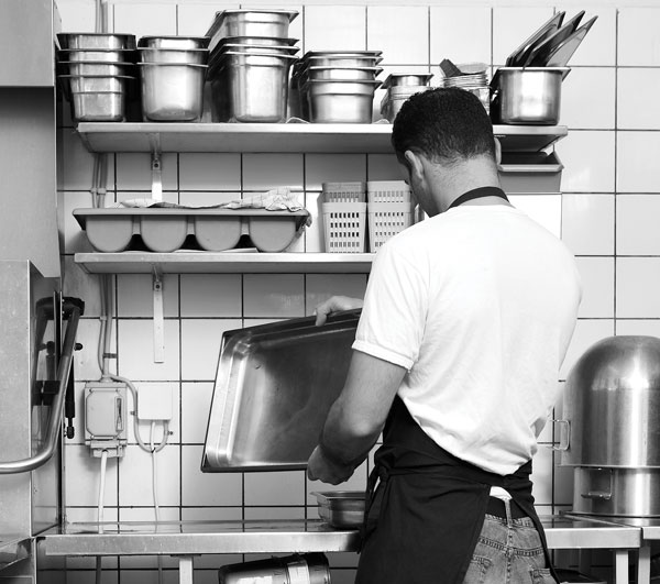 Photo of man washing dishes in restaurant