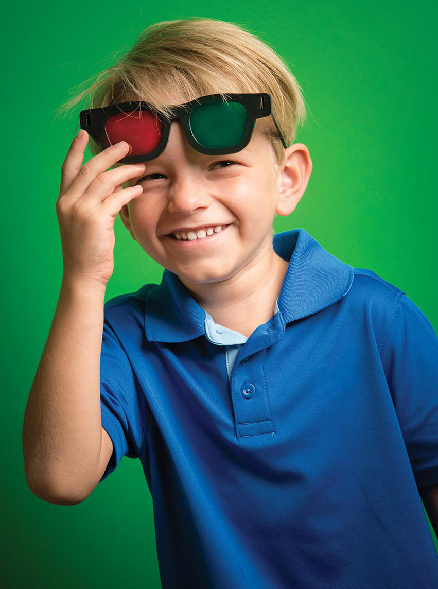 Photo of smiling young boy with red-green glasses