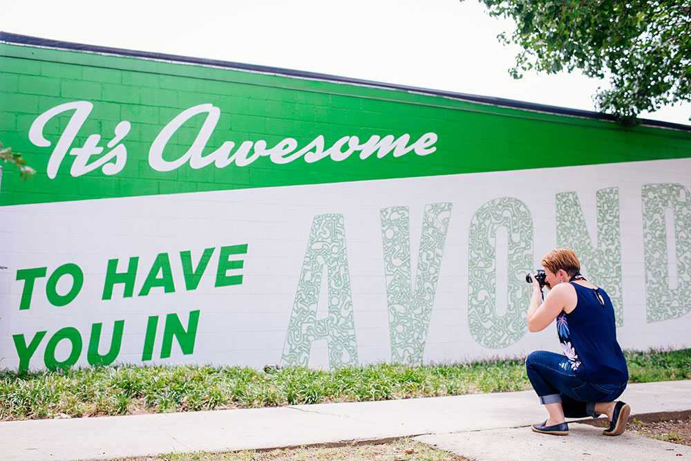 Photo of Viktoria Havasi taking picture of It's Nice to Have You in Avondale mural