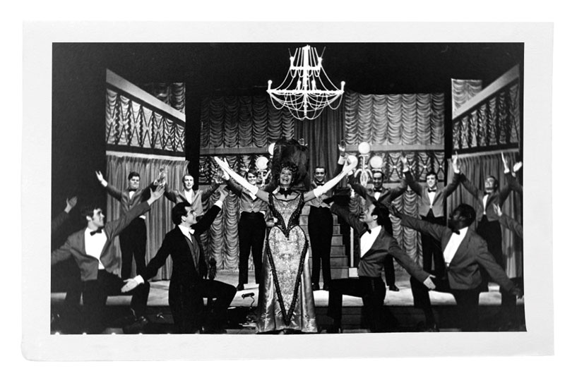 Black and white photo of performance of Hello Dolly!, with actress Boots Carroll at center stage
