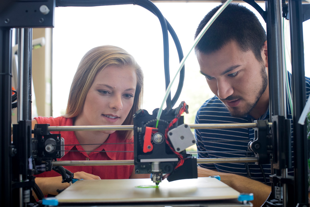 Severino and El-Husari looking at first prototype of their concept on a 3-D printer at the student-run UAB MakerSpace.