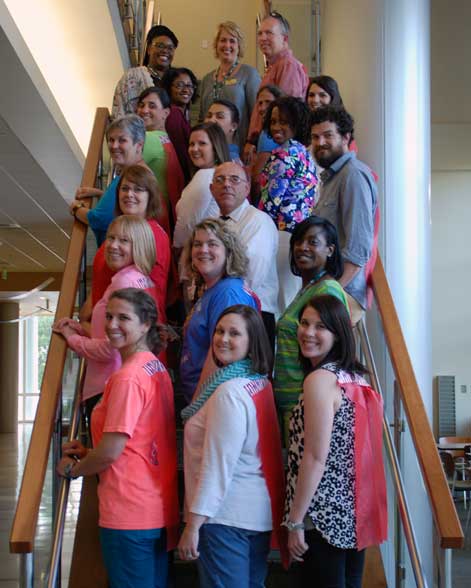 Group of 20 mentor teachers posing on stairwell in Heritage Hall.