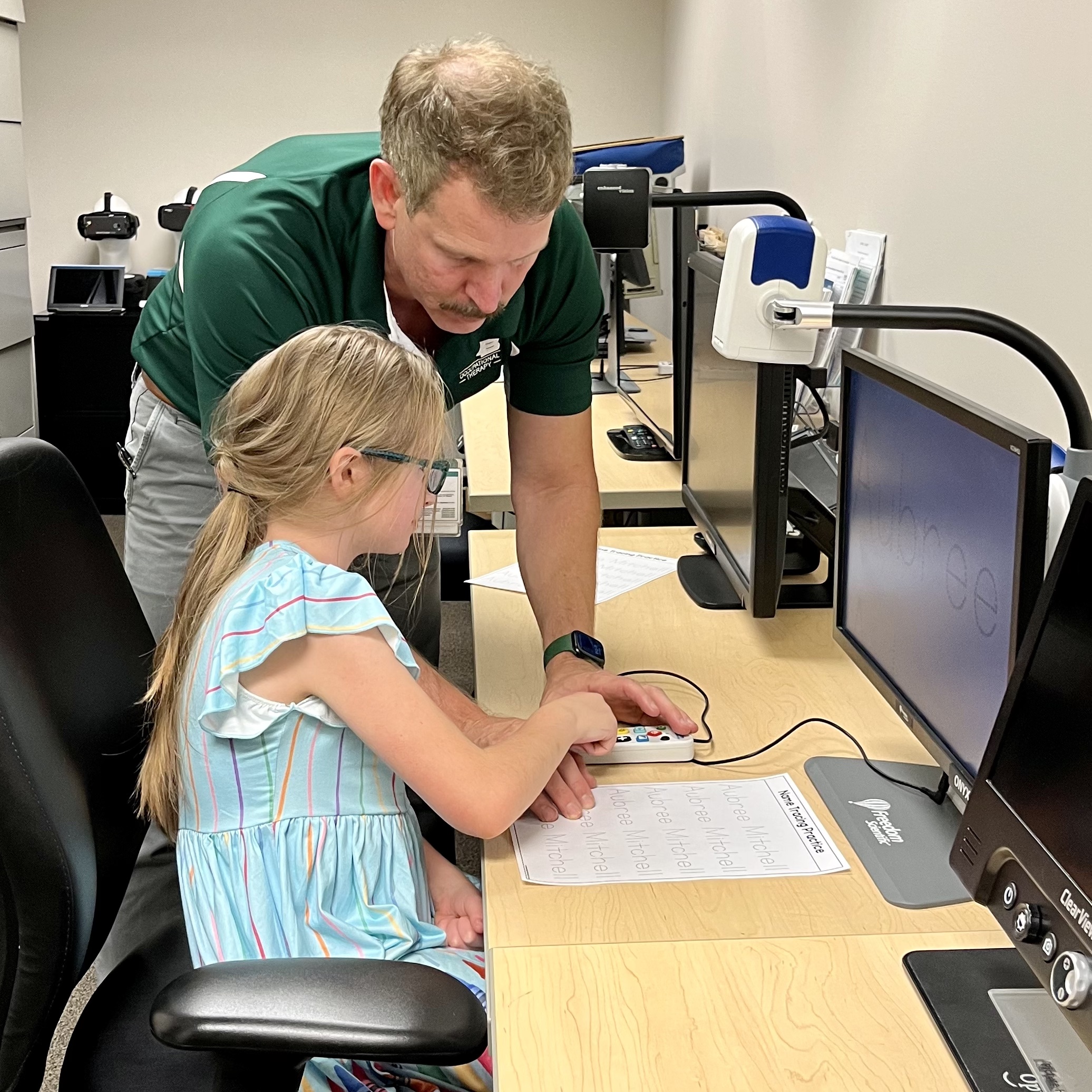 Aubree Mitchel receives training from Jason Vice, Ph.D. on her new vision aid.