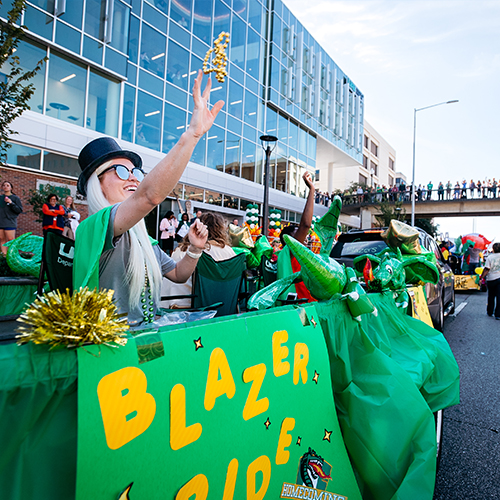 Student throwing beads from a float in the annual homecoming parade.