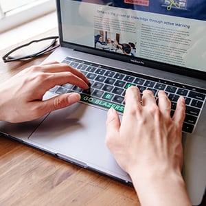 Detail shot of hands on a laptop keyboard.