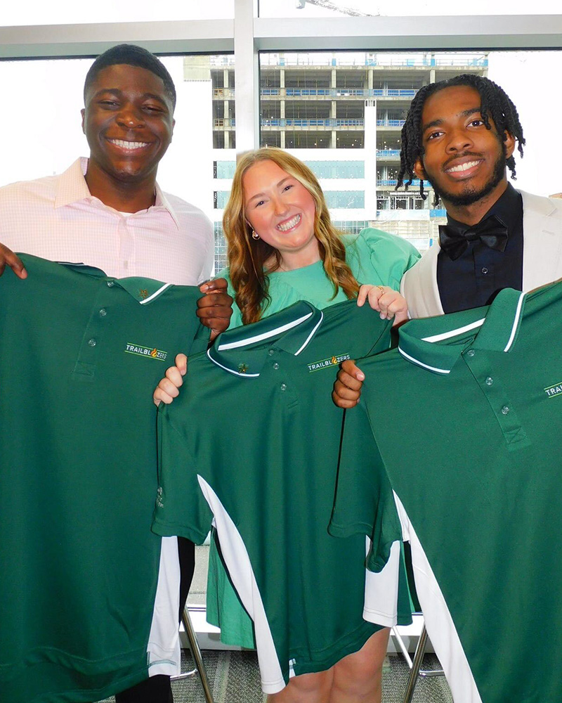 Two Trailblazers possing with the Trailblazer uniform shirt.