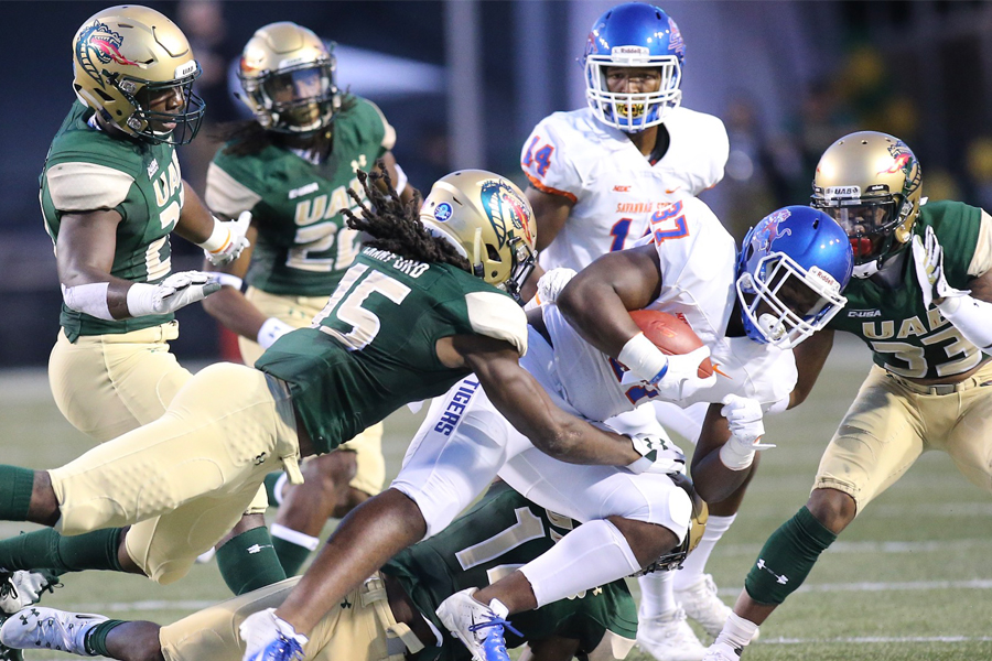 UAB football player tackling an opponent.