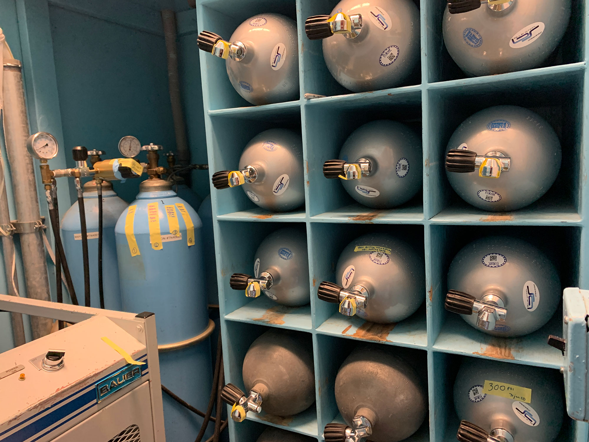 Multiple oxygen tanks stored on shelves. 