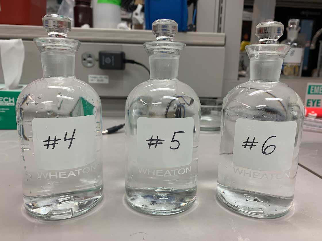 three glass stoppered bottles labeled #4,#5,#6 filled with seawater samples
