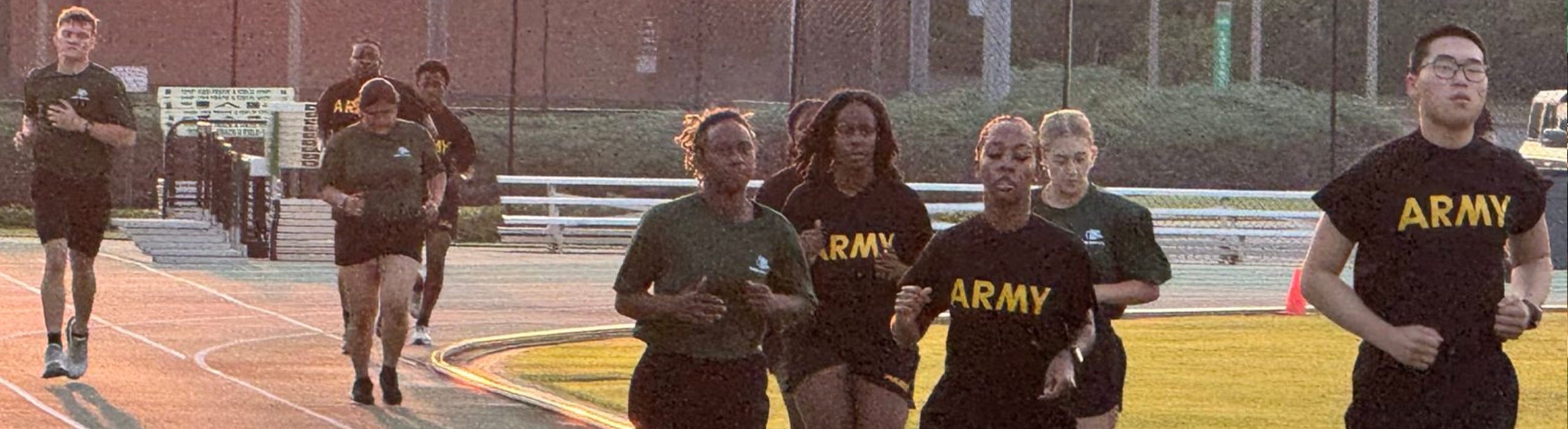 Students running laps around a track wearing their Army tshirts.