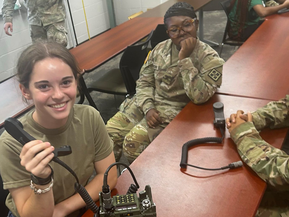 Two female trainees at a table with communication gear.