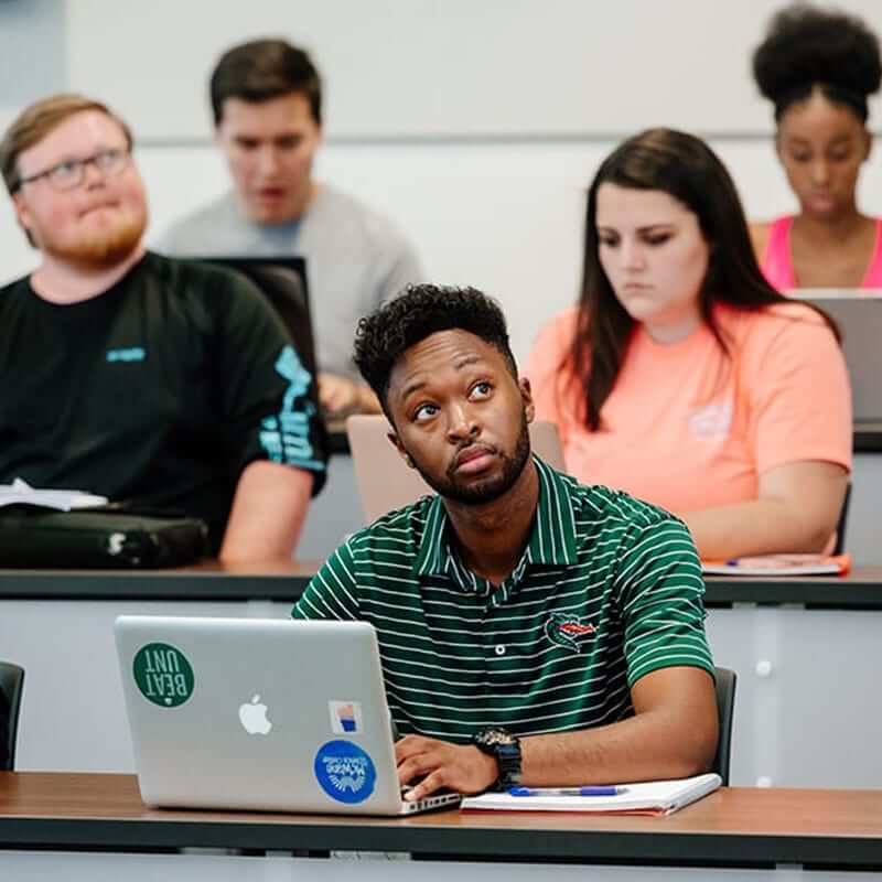 Students sitting at tables in a Collat classroom. 