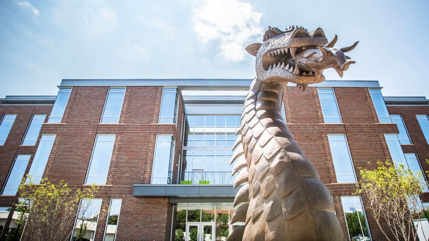 The front of the Collat School of Business Building, with metal Blaze statue in front. 