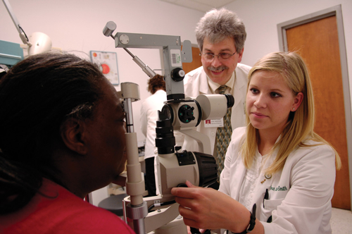 Dr. Felton Perry, OD (Optometry) and unidentified female optometry student examining unidentified African-American female patient, 2007.