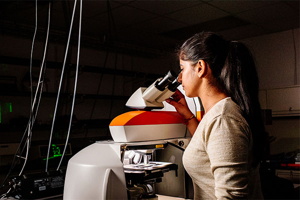Woman using microscope.