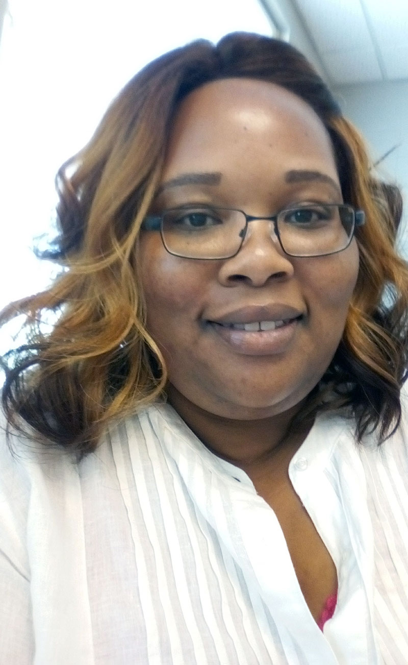 Lorice Tolbert, a smiling Black woman wearing glasses and a white pintucked blouse.