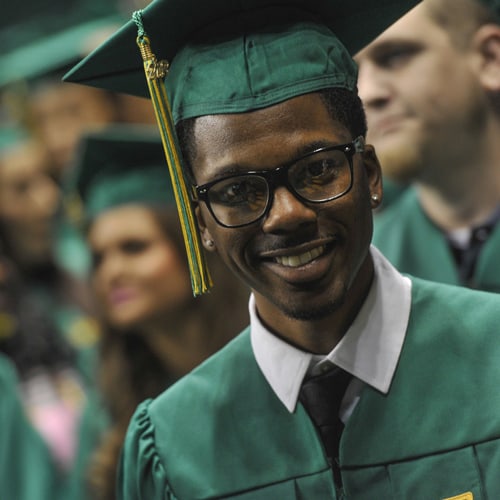 A UAB graduate at commencement ceremonies, wearing his robes and board.