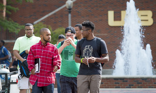 Students walking by a fountain on the UAB campus green. 