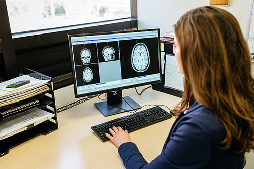 Female student looking at brain scans.