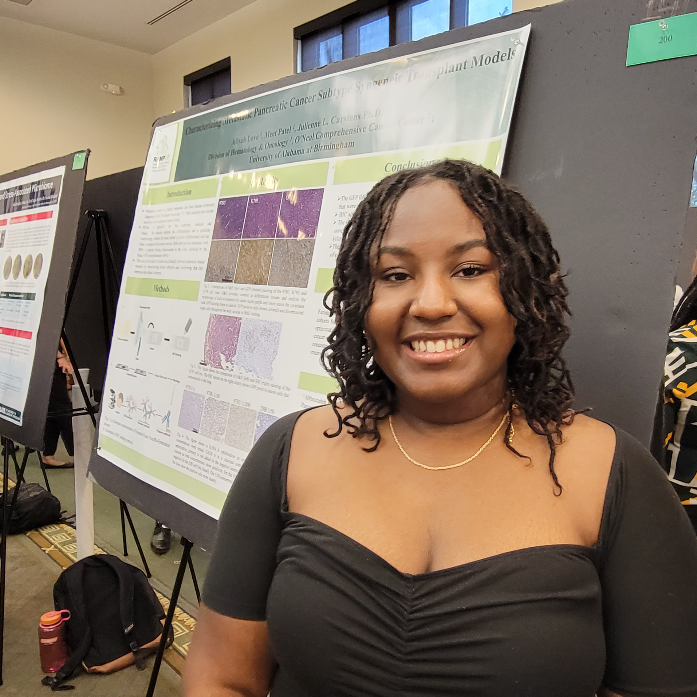 Aliyah Love, rising sophomore studying cancer biology, stands next to her research presentation in the Summer Undergraduate Research Expo.